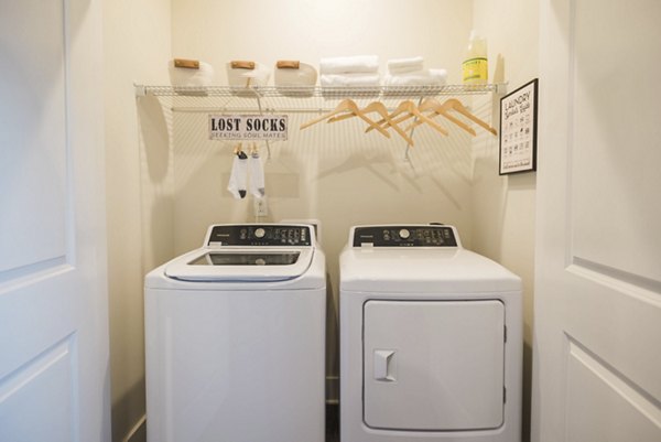 Laundry room with modern washers and dryers at Riverwood Apartments