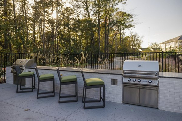 Riverside Apartments: Outdoor grill area with seating and modern design