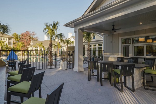 Outdoor patio with stylish seating and lush greenery at Riverwood Apartments