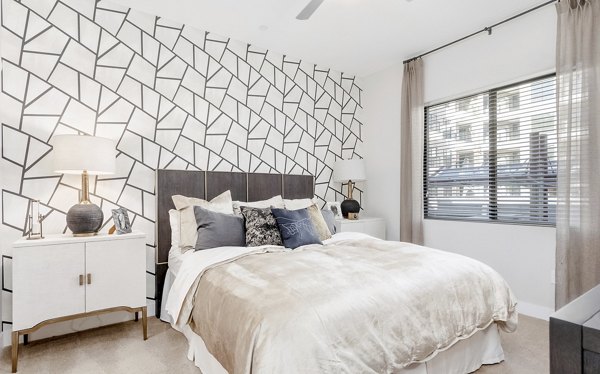 Cozy bedroom with modern decor and large windows at The Griffin Apartments