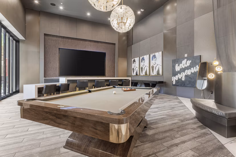 Stylish game room with pool table and lounge seating at The Griffin Apartments