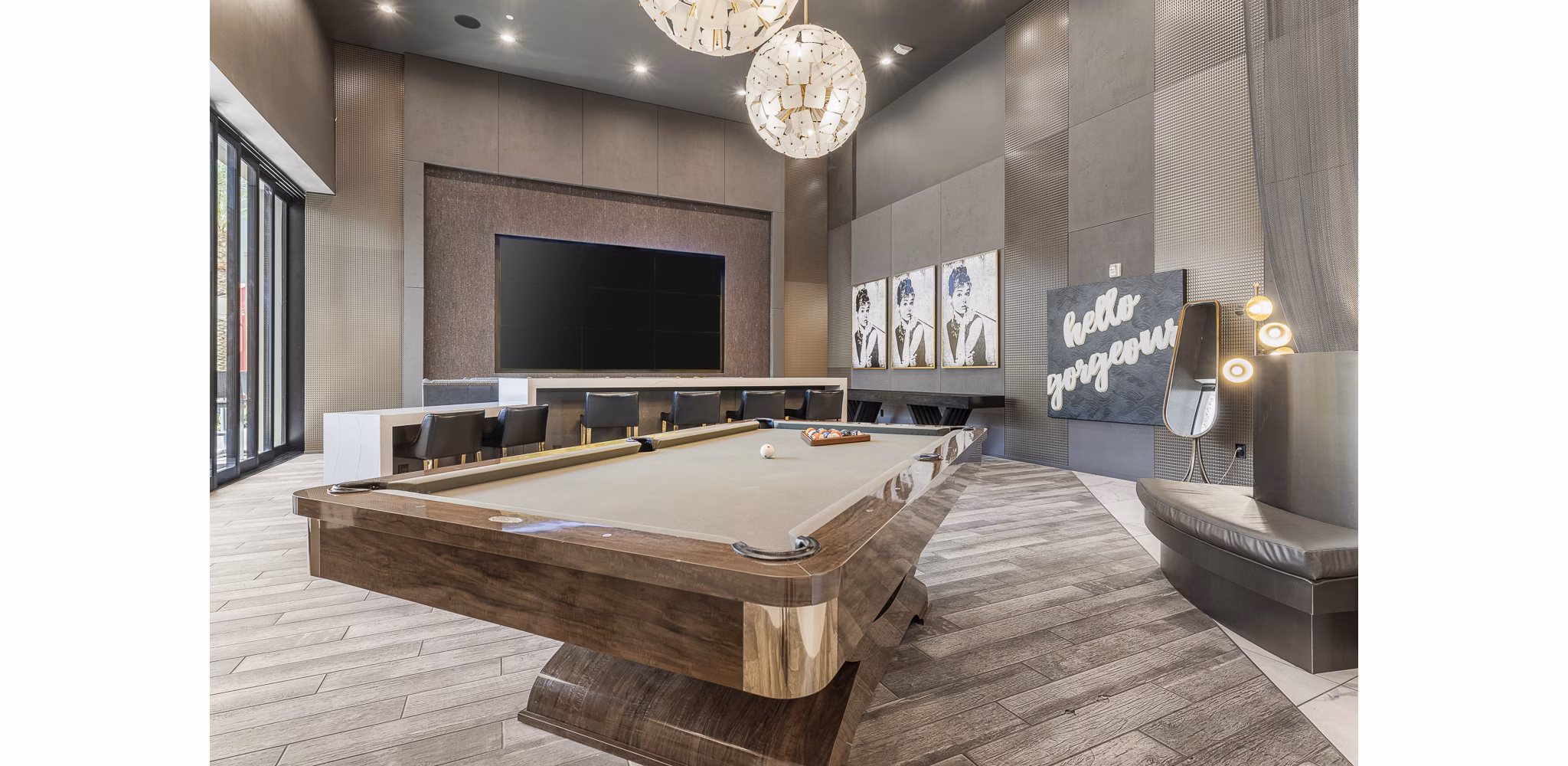 Stylish game room with pool table and lounge seating at The Griffin Apartments