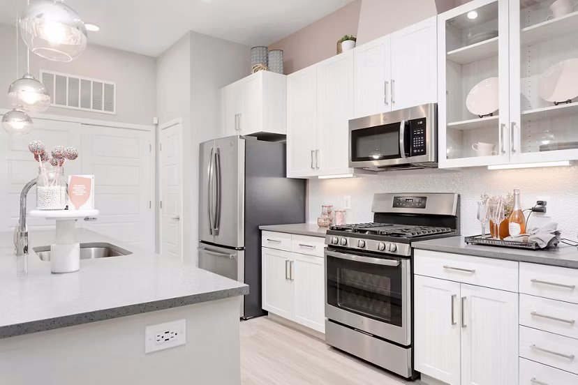 Modern kitchen featuring stainless steel appliances and granite countertops in The Griffin Apartments