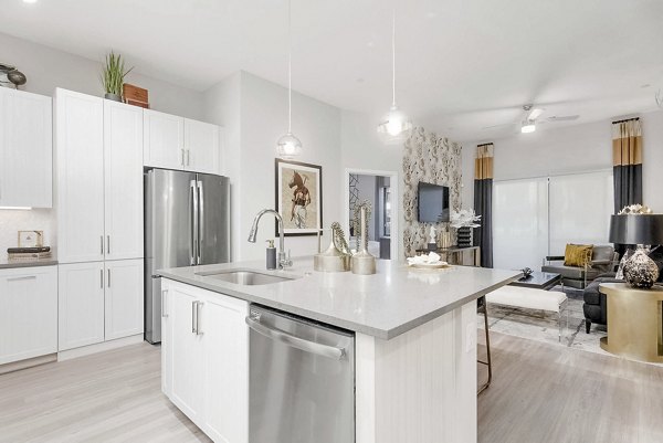 Modern kitchen with sleek appliances and island at The Griffin Apartments