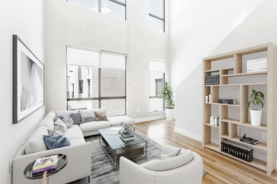 Spacious living room featuring modern decor and ample natural light at The Griffin Apartments