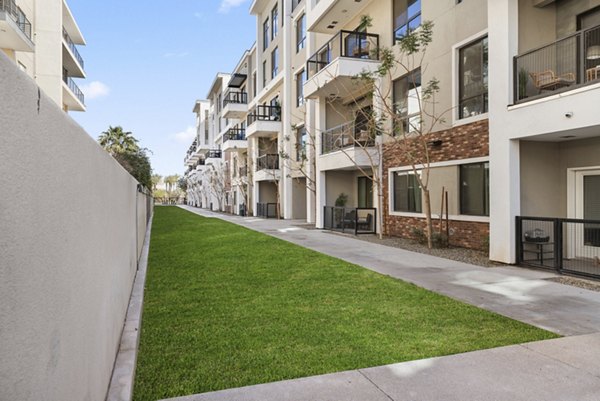 The Griffin Apartments: Green courtyard with seating and lush landscaping