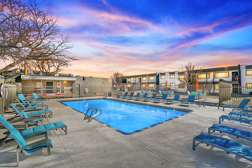 Resort-style pool with lounge chairs at Tesota Four Hills Apartments