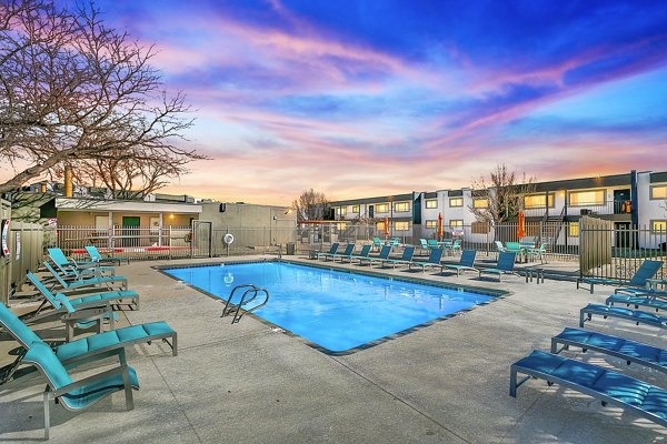 Resort-style pool with lounge chairs at Tesota Four Hills Apartments