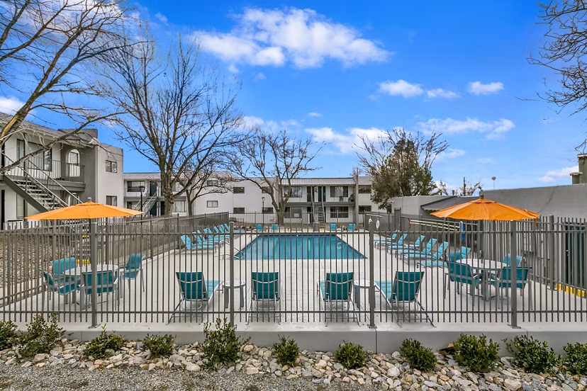 Sparkling outdoor pool at Tesota Midtown Apartments, a luxury Greystar community, surrounded by lush greenery and lounge seating