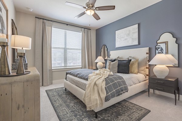 Bedroom with large windows and modern furnishings at Filament Apartments, luxurious living spaces in a vibrant community