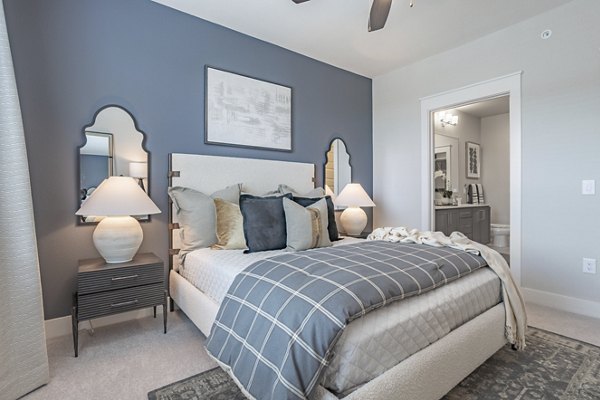 Contemporary bedroom with chic design and large windows at Filament Apartments, a luxury living space ideal for modern comfort