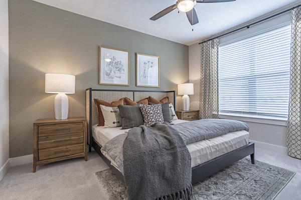 Cozy bedroom with modern furnishings at Filament Apartments featuring luxury living in the heart of the city