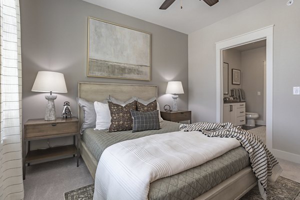 Bedroom featuring modern decor and large windows at Filament Apartments