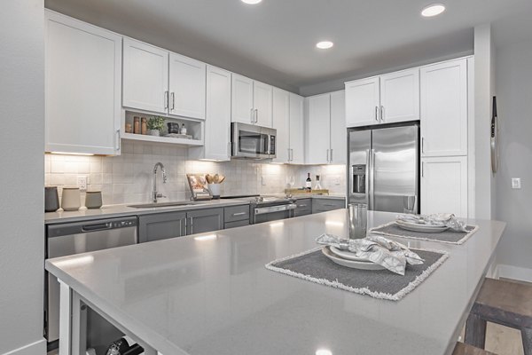 Modern kitchen featuring stainless steel appliances and quartz countertops at Filament Apartments