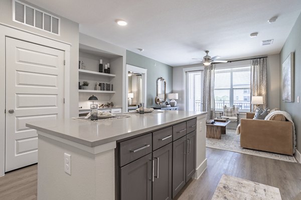 Modern kitchen with island and stainless steel appliances at Filament Apartments