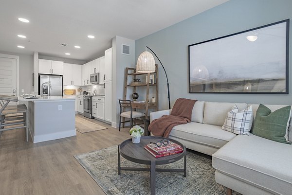 Spacious living room with modern decor featuring natural light at Filament Apartments