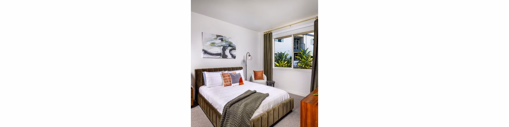 Cozy bedroom with modern decor in Paloma Apartments featuring luxurious bedding and ample natural light