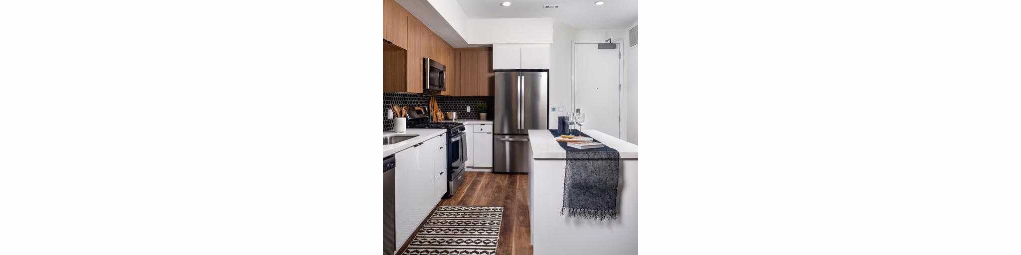 Modern kitchen featuring stainless steel appliances and granite countertops in Paloma Apartments
