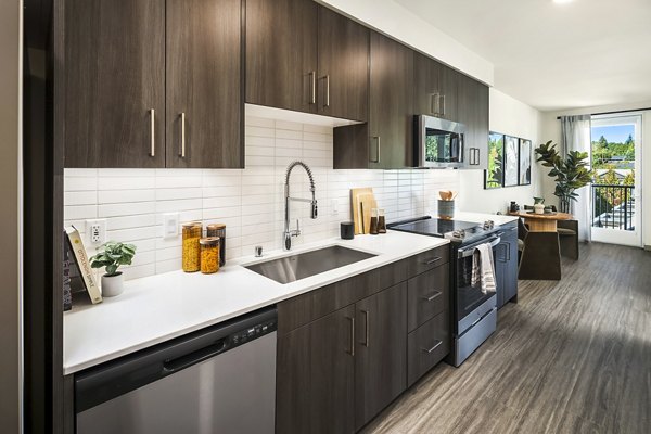 Modern kitchen with stainless steel appliances in Broadstone Strata Apartments