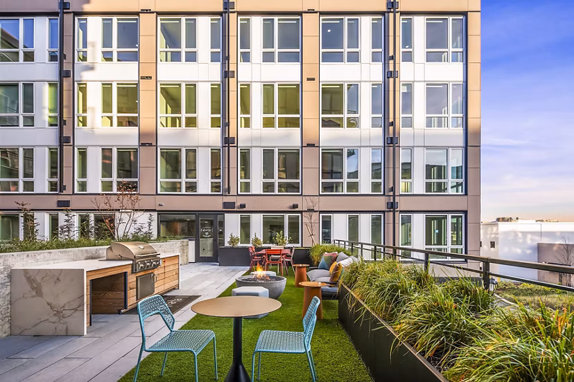 Outdoor patio with BBQ grill area at Broadstone Strata Apartments, featuring stylish seating and landscaped surroundings for social gatherings