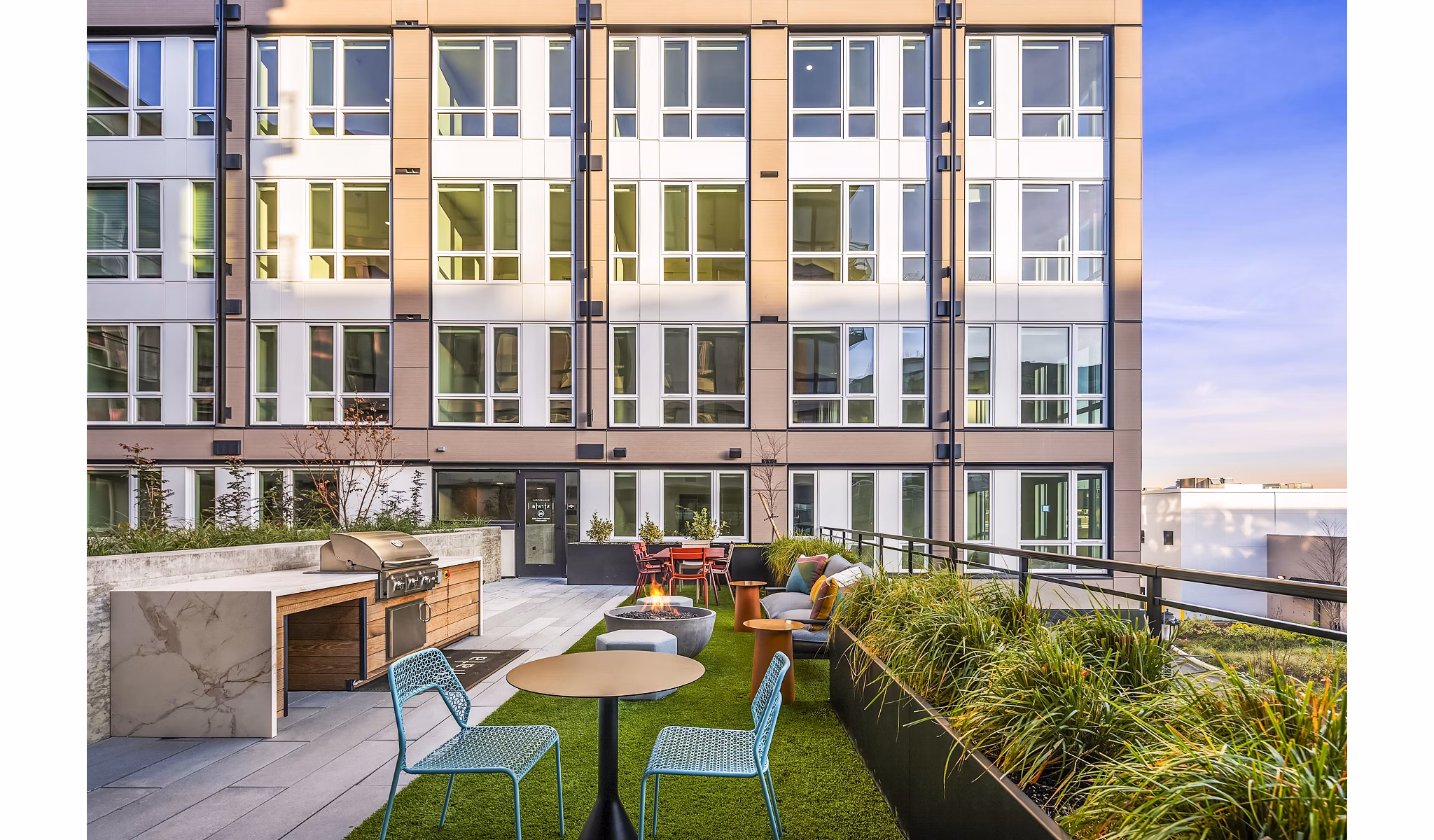 Outdoor patio with BBQ grill area at Broadstone Strata Apartments, featuring stylish seating and landscaped surroundings for social gatherings