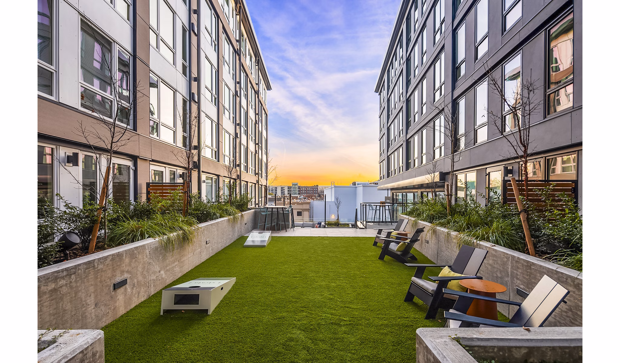 Outdoor patio and recreational area with seating and greenery at Broadstone Strata Apartments, perfect for relaxation and social gatherings