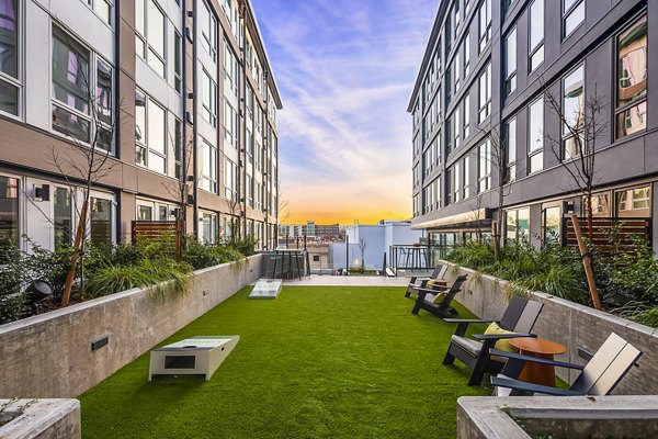 Outdoor patio and recreational area with seating and greenery at Broadstone Strata Apartments, perfect for relaxation and social gatherings