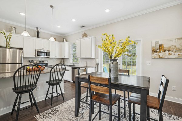 Dining area with cozy seating and modern lighting at Ailsa Village Apartments, offering luxury living in a serene environment