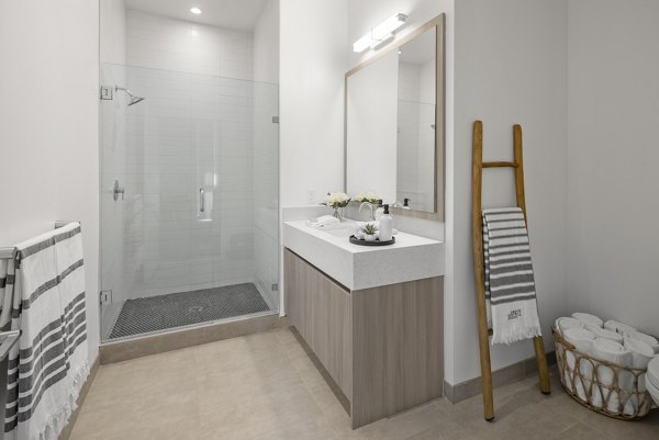 Bathroom featuring modern fixtures and marble countertops in Grove Central Residences Apartments