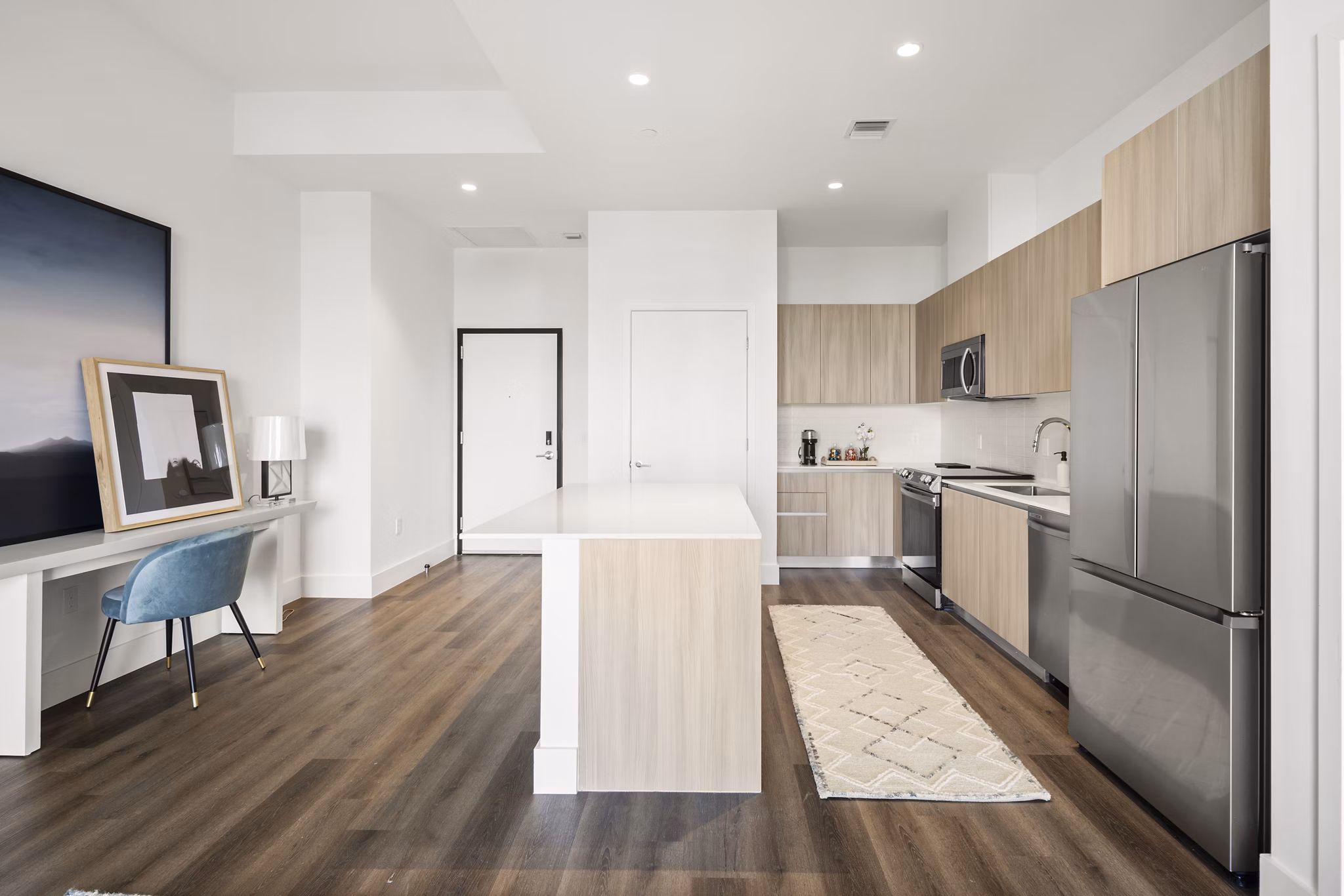 Modern kitchen with stainless steel appliances and island seating at Grove Central Residences Apartments