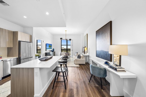 Modern kitchen with granite countertops and stainless steel appliances in Grove Central Residences Apartments