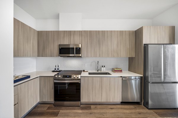 Contemporary kitchen with stainless steel appliances at Aventura Bellevue Apartments