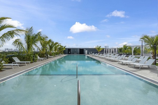 Relaxing outdoor pool with lounge chairs at Grove Central Residences Apartments, perfect for summer leisure and recreation