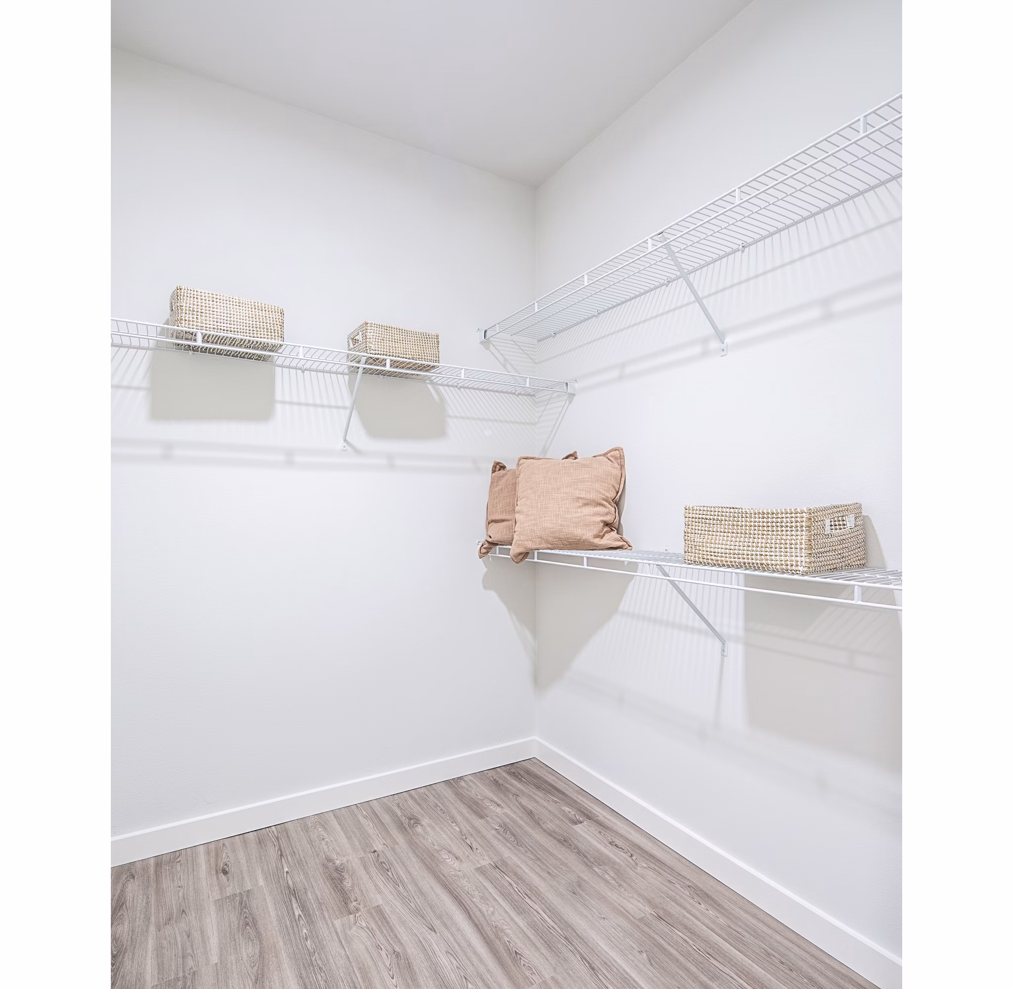 Spacious walk-in closet with wire shelving and organized wicker baskets in luxury apartment