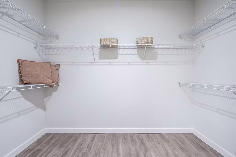Spacious walk-in closet with wire shelving and storage baskets at luxury apartments