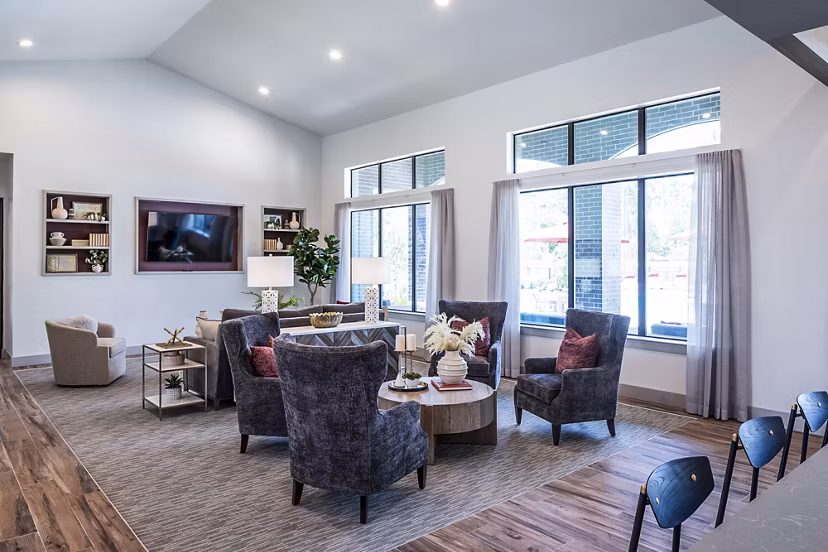 Modern living room with stylish chairs and large windows in luxury apartments