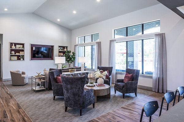 Modern living room with stylish chairs and large windows in luxury apartments