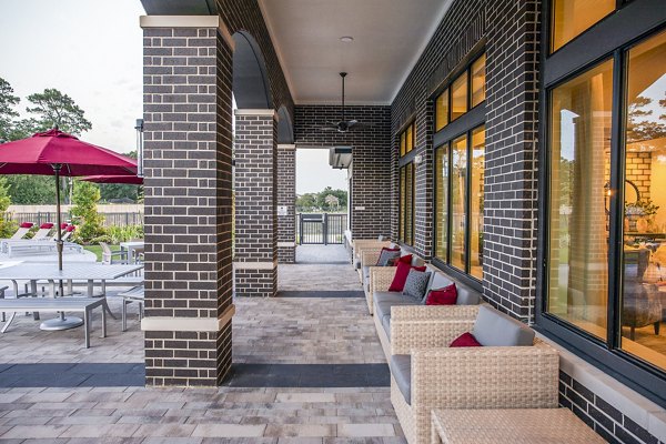Inviting outdoor patio with brick columns and wicker seating at luxury apartments