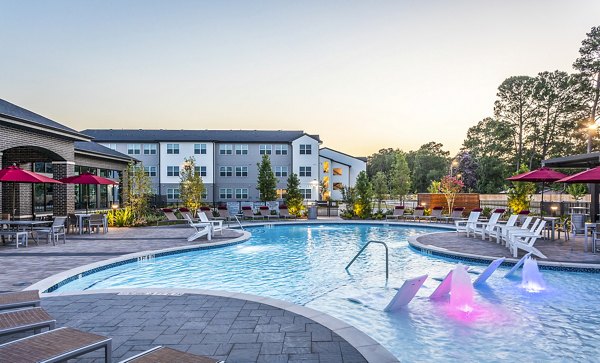 Swimming pool area with lounge chairs and umbrellas at luxury apartments