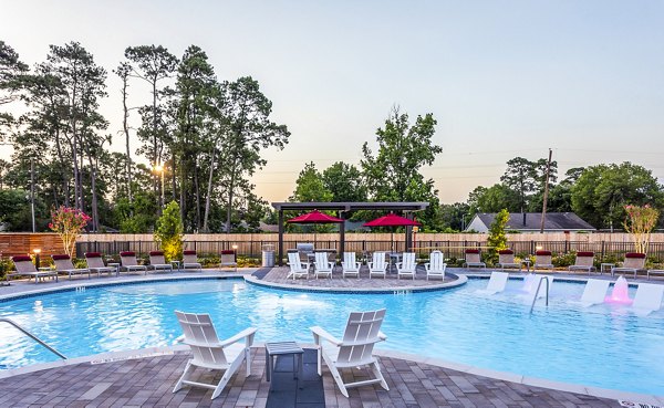 Relaxing swimming pool area with lounge chairs and umbrellas at luxury apartments