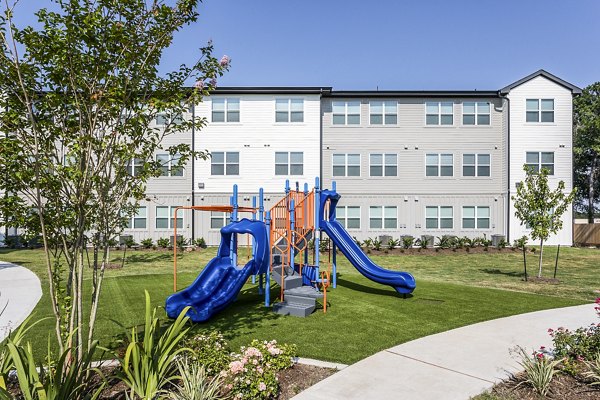 Playground with blue slides and climbing equipment at luxury apartments