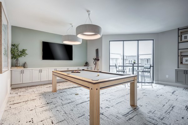 Game room with pool tables and lounge seating at Prospect Apartments