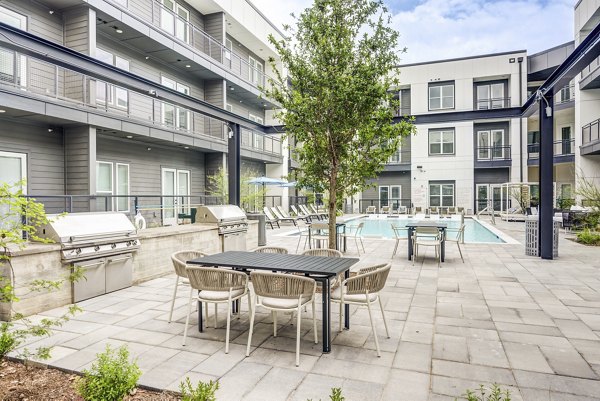 Stylish outdoor grill area with modern seating at Prospect Apartments, a luxury community by Greystar