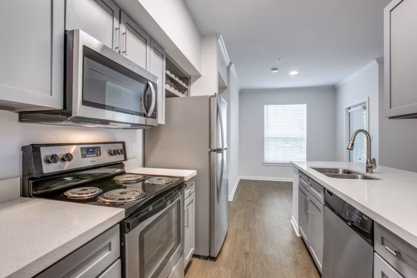 Modern kitchen with stainless steel appliances and granite countertops in Oak Crest Apartments