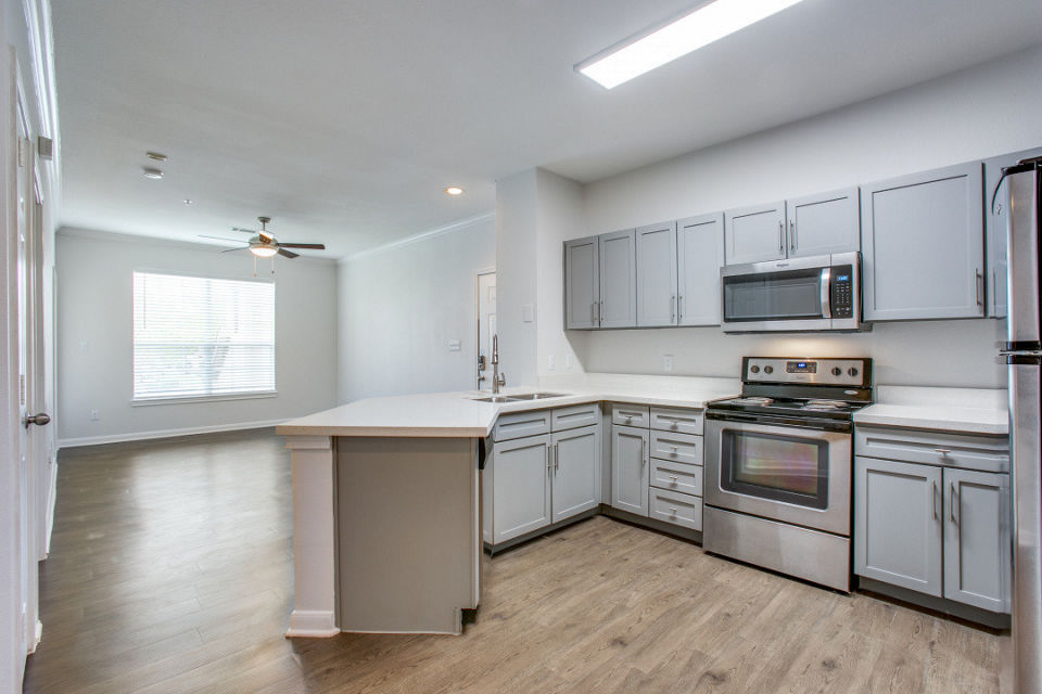 Oak Crest Apartments: Modern kitchen with stainless steel appliances and sleek countertops at luxury apartments in prime location