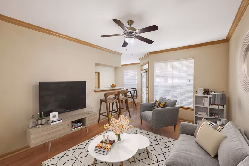 Spacious living room with contemporary design elements in Woodland Park Apartments, featuring large windows and modern decor