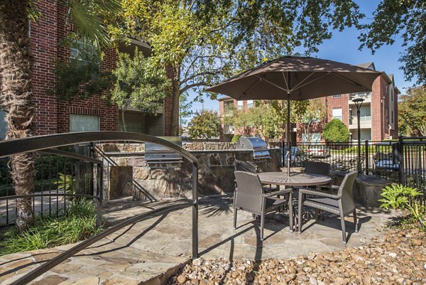 Outdoor grill area with modern seating at Woodland Park Apartments, perfect for social gatherings and BBQs
