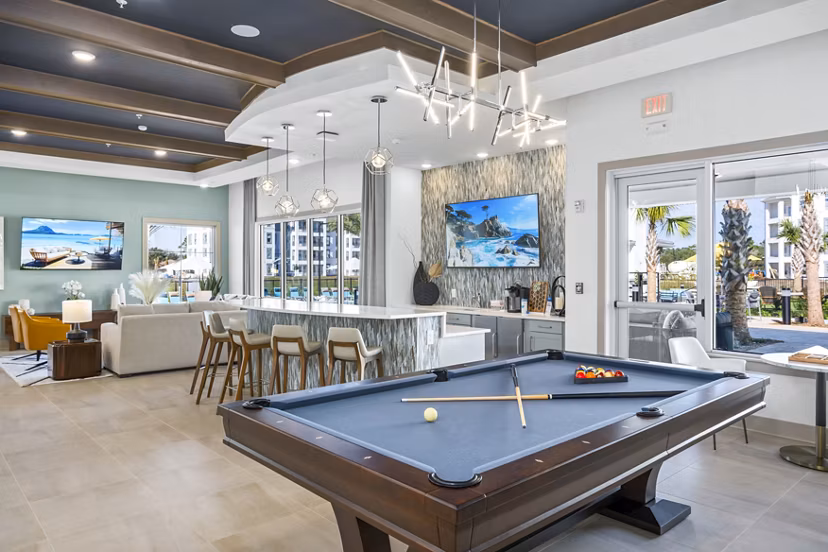 Clubhouse game room with billiards and lounge seating at Sanctuary at Daytona Apartments