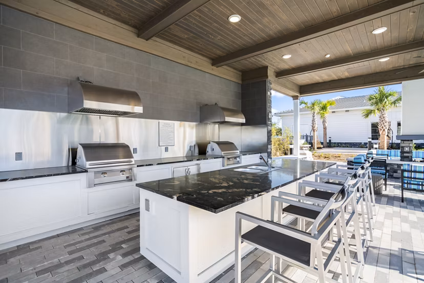 Outdoor grill area with modern patio seating at Sanctuary at Daytona Apartments