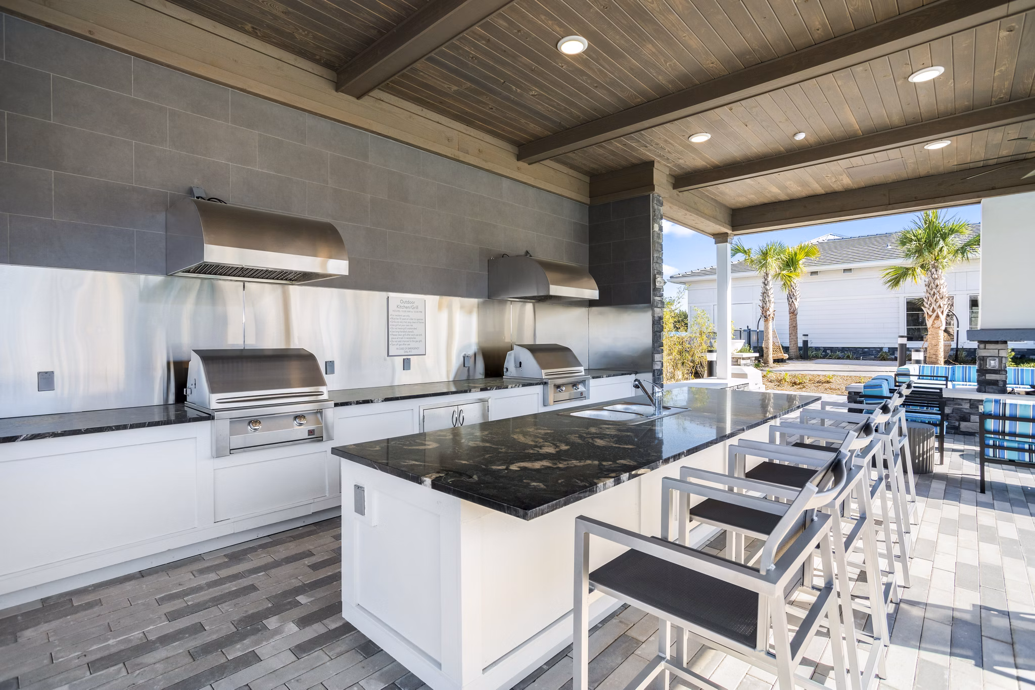 Outdoor grill area with modern patio seating at Sanctuary at Daytona Apartments